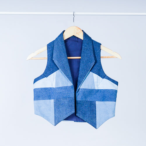 A denim vest with a structured, geometric design, displayed on a hanger against a white background.